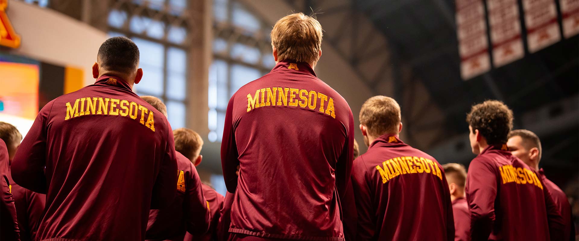 The backs of athletes in Minnesota jackets