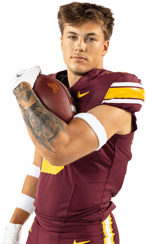 Football player posing in uniform holding football