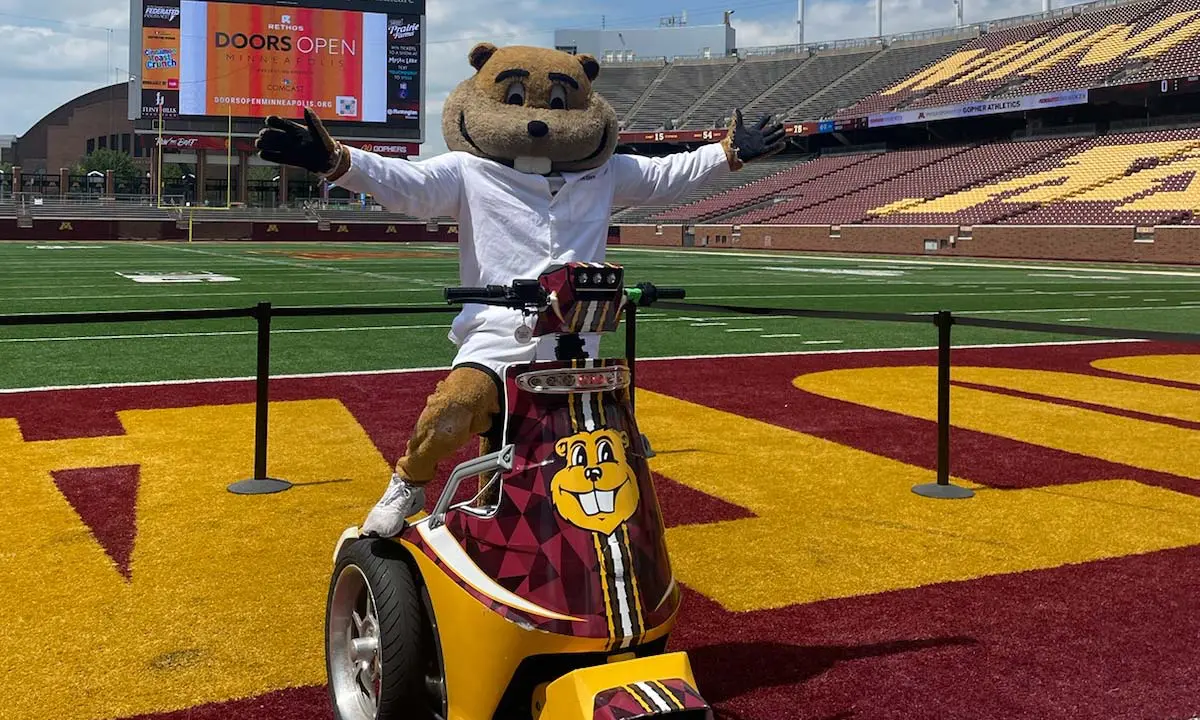 Goldy gopher posing with a moped