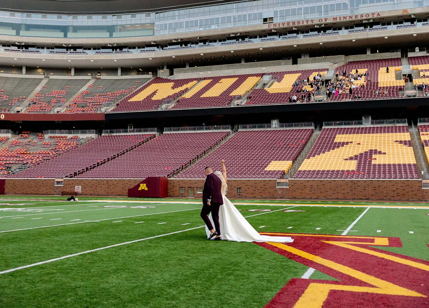 View of bride and groom walking on football field