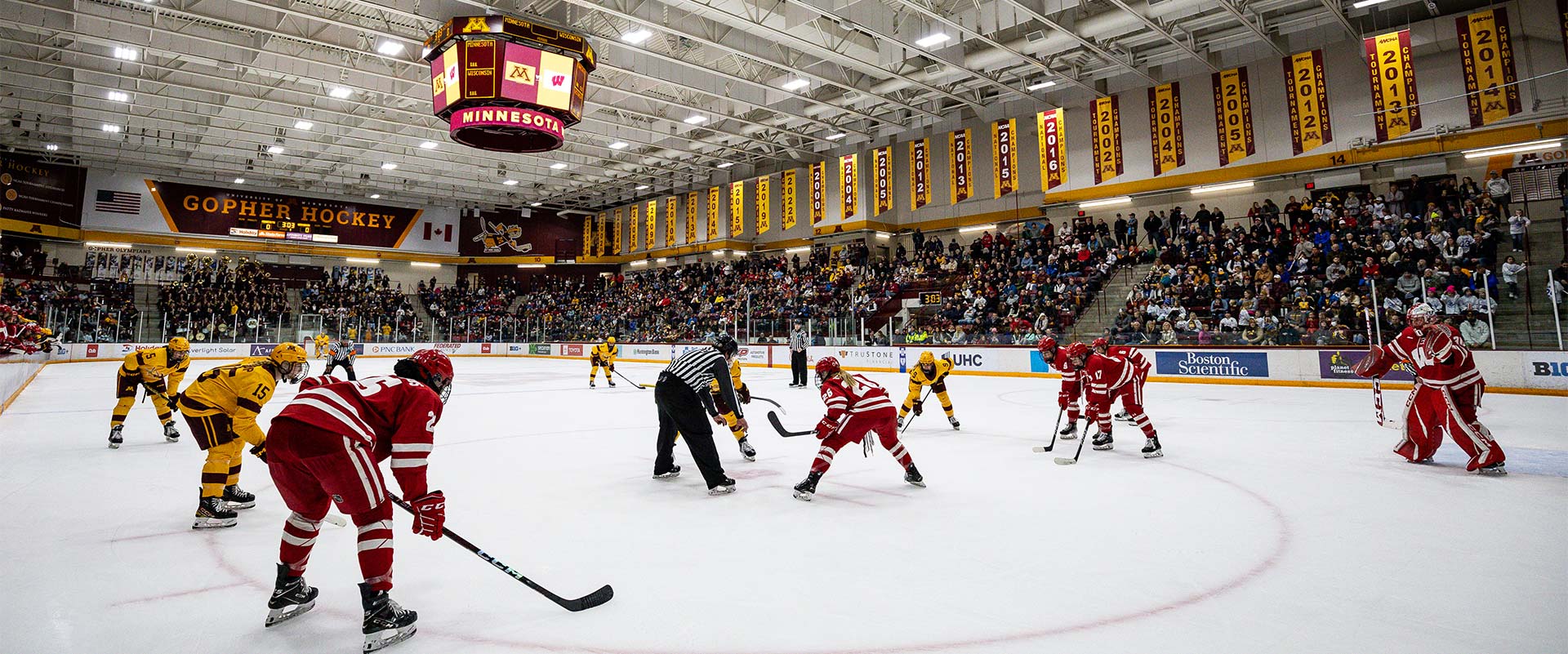 Hockey players on the ice in a full arena