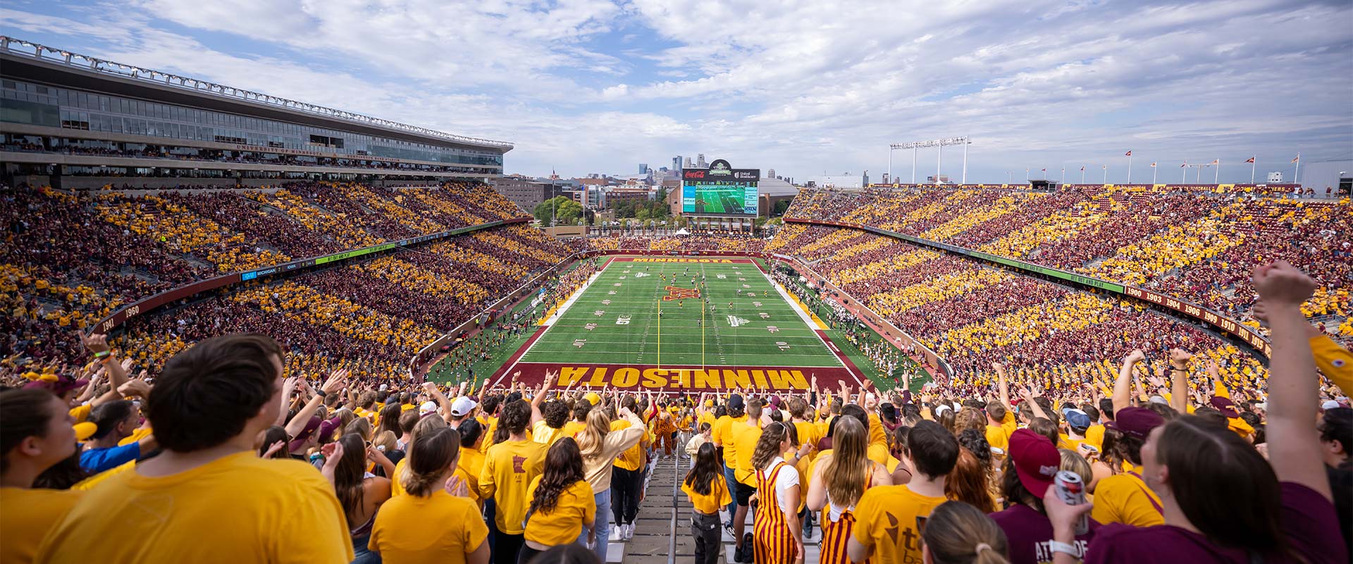 View of football field from over a fan's shoulder